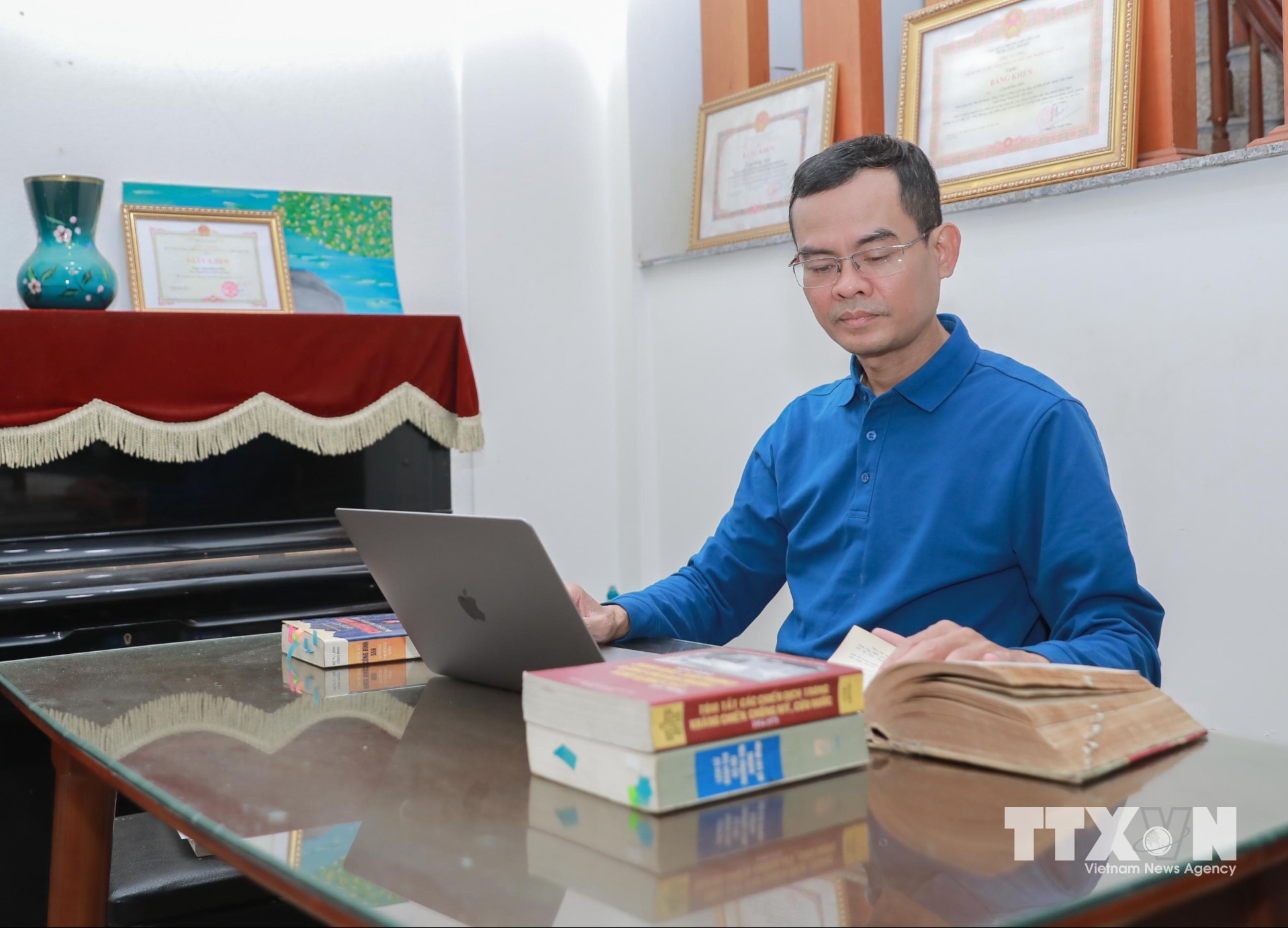 KTS Lâm Hồng Tiến (Hà Nội) tranh thủ thời gian ngoài giờ, cuối tuần khai thác kho tư liệu chiến tranh tại Đại học Texas (Hoa Kỳ), thu thập kỷ vật, ứng dụng công nghệ số và đăng tải trên kyvatkhangchien.com, góp phần hỗ trợ các gia đình liệt sĩ. (Ảnh: Phan Phương/TTXVN)